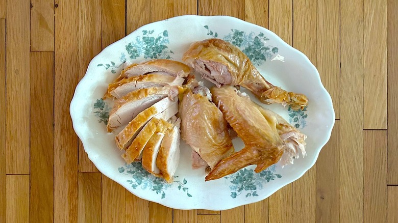 Platter of carved roasted turkey with sliced breast, thigh, leg, and wing