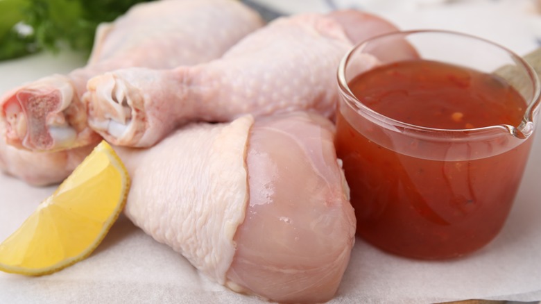 Raw chicken next to marinade ingredients