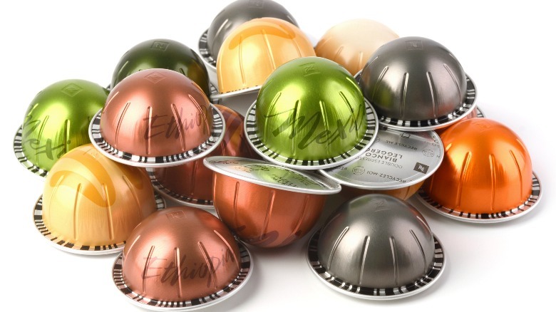 Nespresso Vertuo pods sit on a white surface, showing off the barcode printed on the underside of the rim.