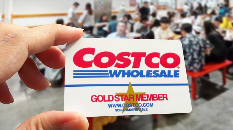 A hand holding a Costco membership card