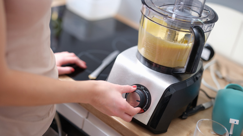 person adjusting food processor speed