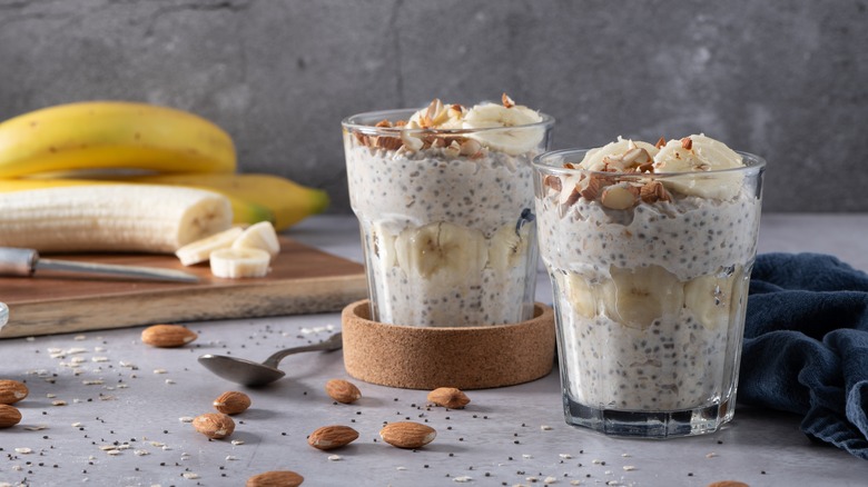 overnight oats in glass cups surrounded by fruit