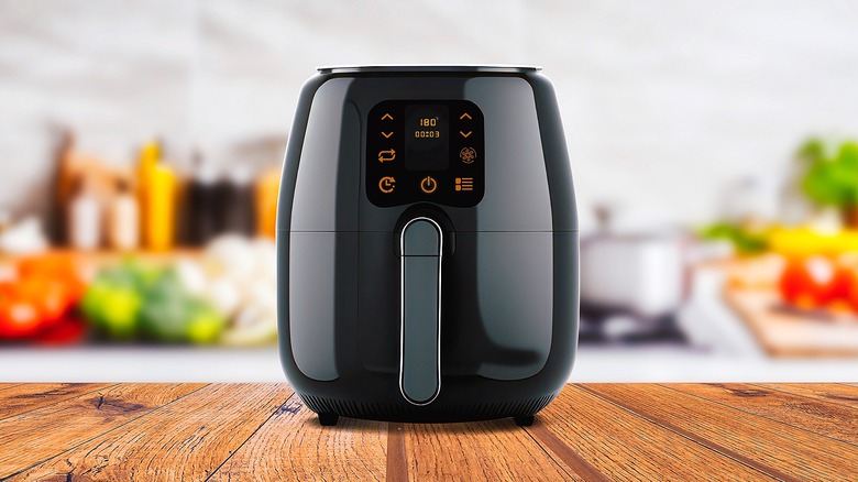 Black air fryer on wooden countertop