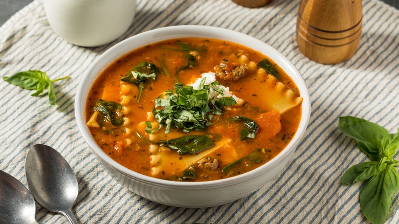 A bowl of lasagna soup topped with herbs