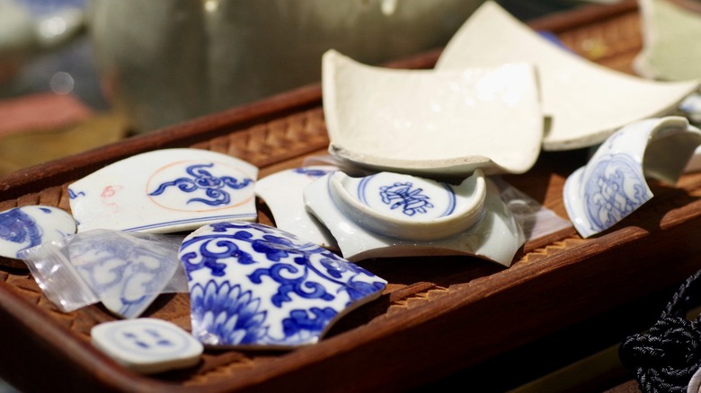 Broken blue and white china on a bamboo tea tray