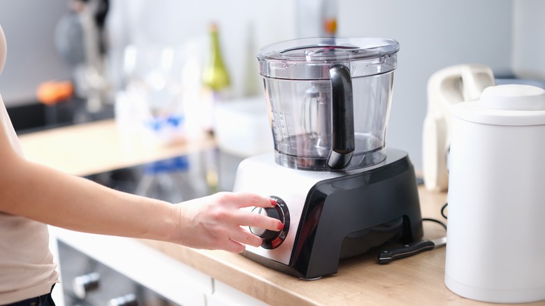 Person touching food processor dial