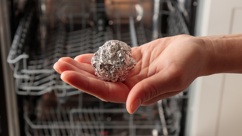Hand holding an aluminum foil ball