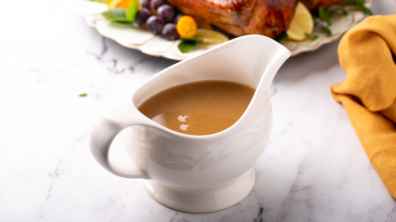 Turkey gravy in a white gravy boat on the Thanksgiving table