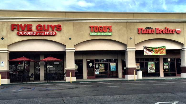 A strip mall with Five Guys, Togo's, and Flame Broiler