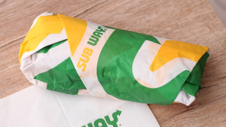 A Subway sandwich rolled up in paper