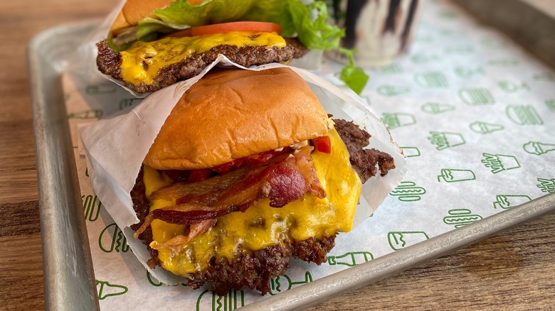 Shake Shack burgers on a tray lined with branded paper