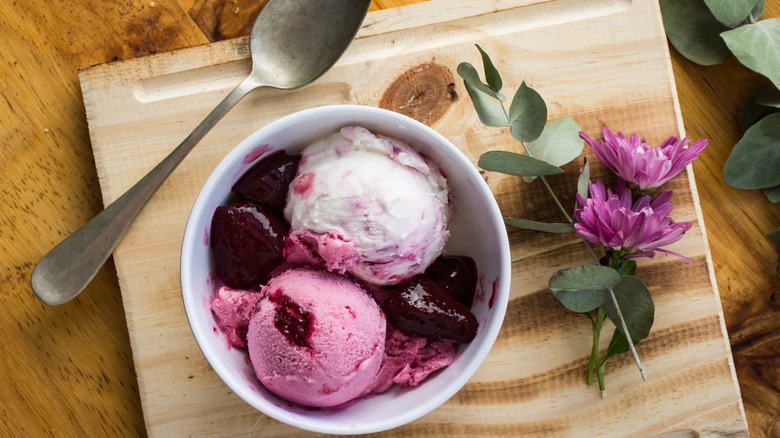 two scoops of strawberry and mascarpone ice cream in a bowl with flowers