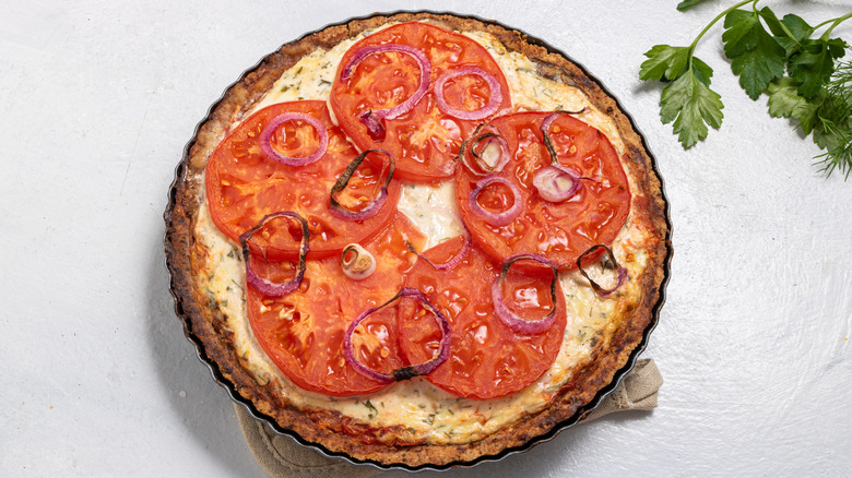 Baked tomato pie with tomato slices on top and red onion