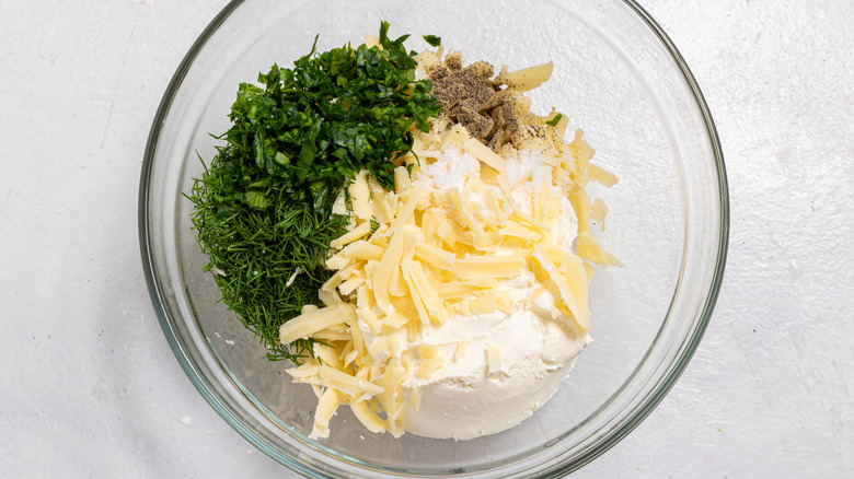 Bowl with cream cheese, cheddar cheese, dill, parsley, black pepper, and salt