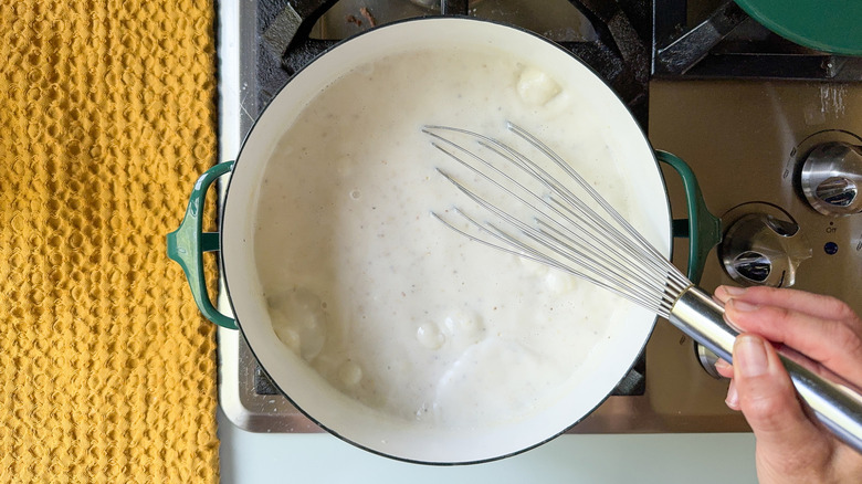 Whisking grits in pot on stovetop