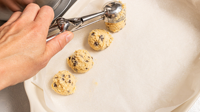 hand scooping cookie dough balls