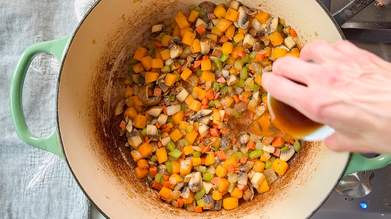 Adding sherry to cooked vegetables in Dutch oven on stovetop