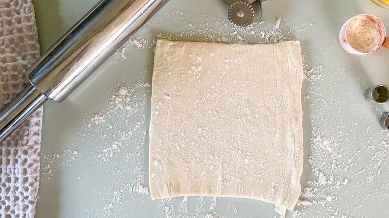 Puff pastry on work surface with rolling pin and cutters