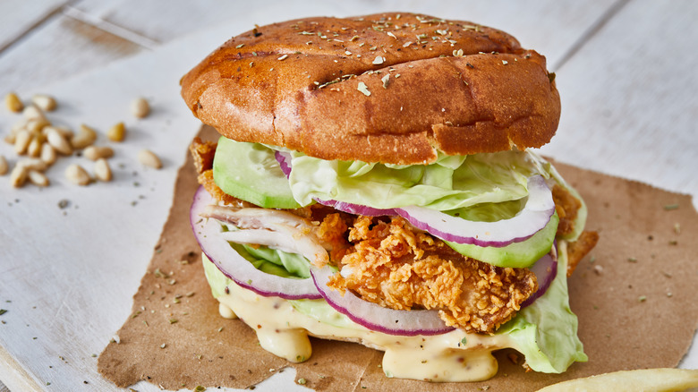 Chicken sandwich with lettuce, onions, and sauce