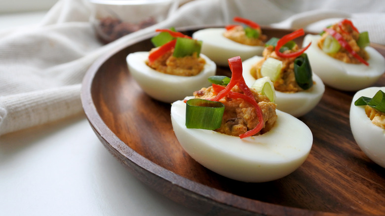 Deviled eggs with red peppers and scallion topping