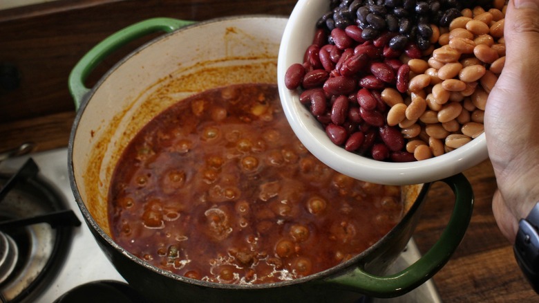 adding beans to chili pot