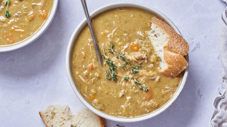 split pea soup in bowl with bread and spoon
