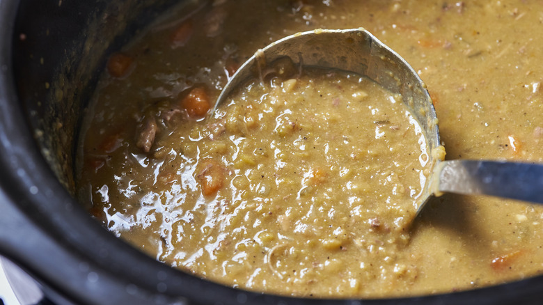 ladle dipping into pot of split pea soup
