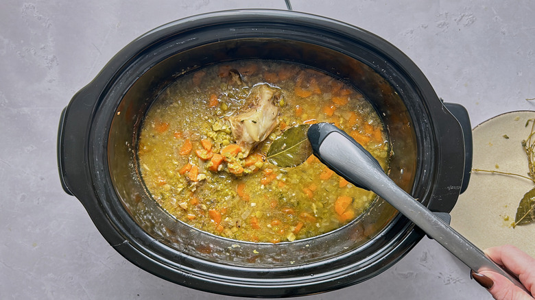 removing leaf from slow cooker with tongs