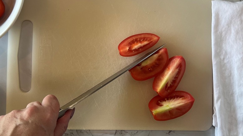 hand chopping tomatoes