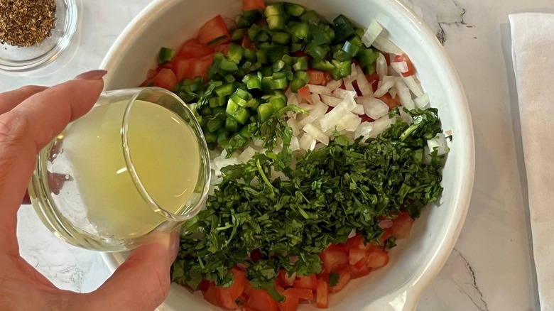 pouring lime juice into salsa