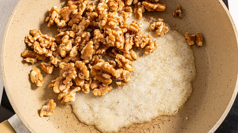 Walnuts and melted sugar in a skillet