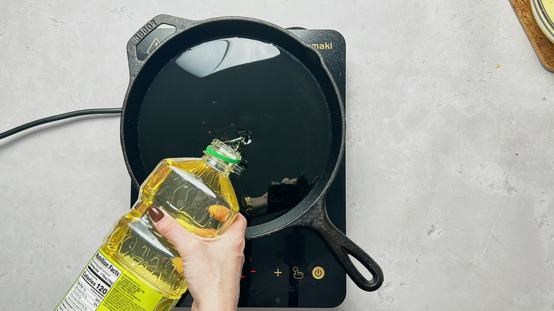adding oil to a skillet