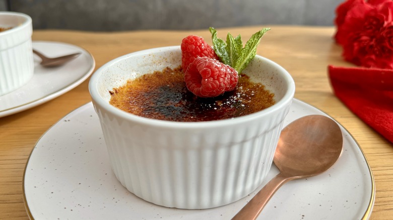 creme brulee in ramekin next to spoon