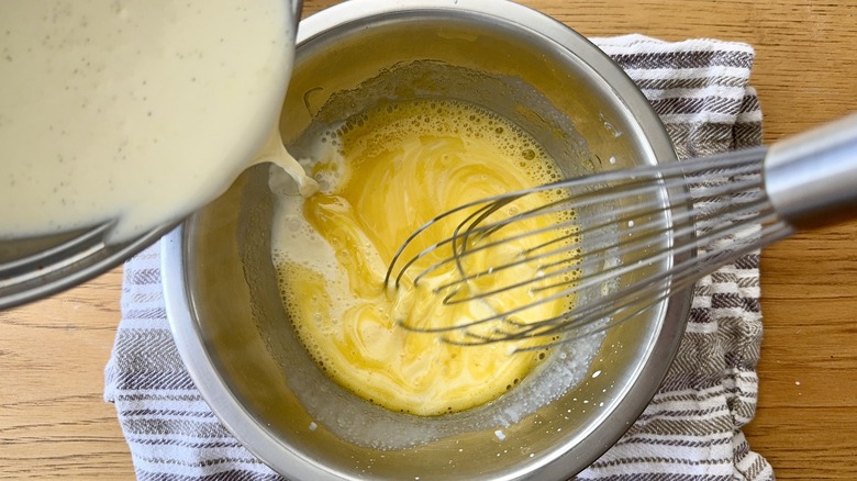 Whisking hot cream into egg yolks