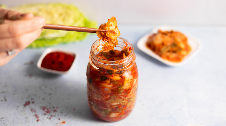 chopsticks taking kimchi from the jar