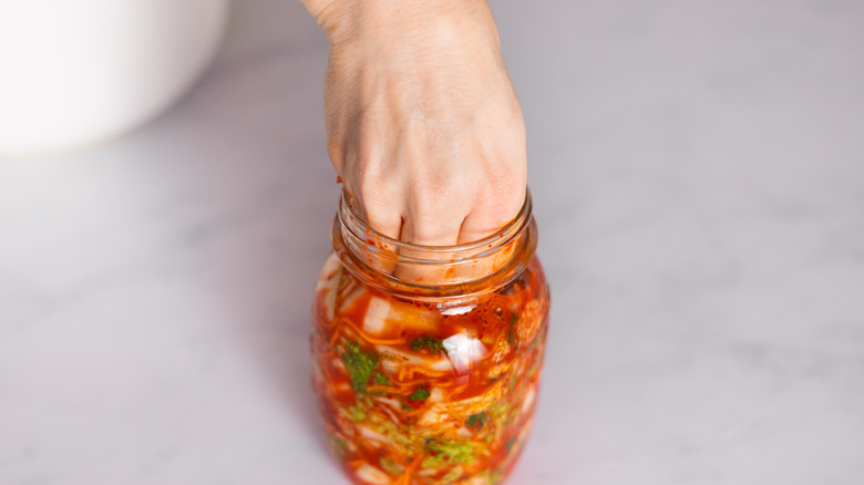 hand packing kimchi into jars 