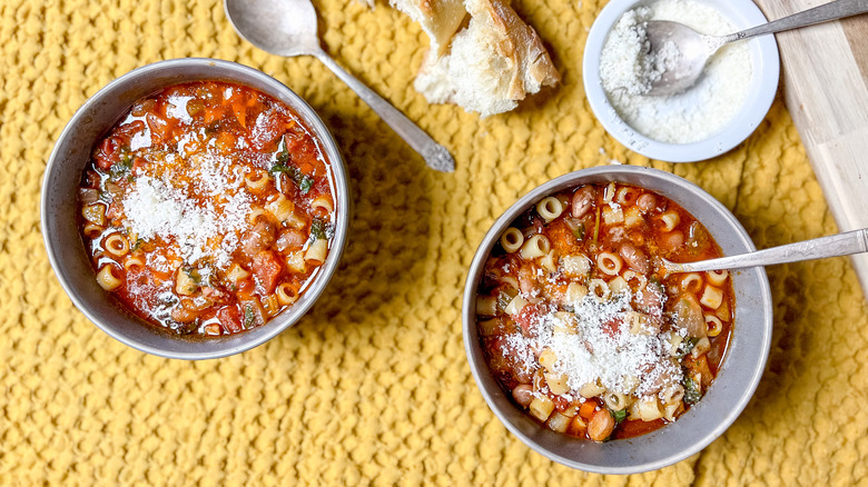 Classic pasta e fagioli in bowls with parmesan on table