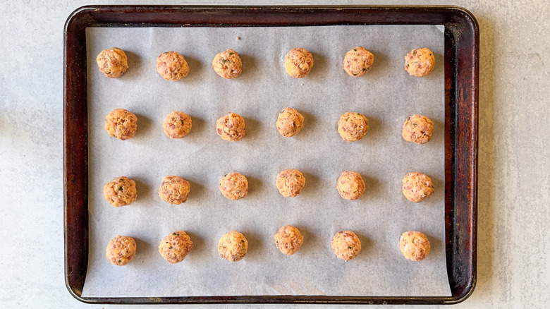 Raw classic sausage balls on parchment-lined baking sheet