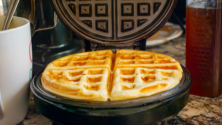 Fresh waffle cooking on round waffle iron