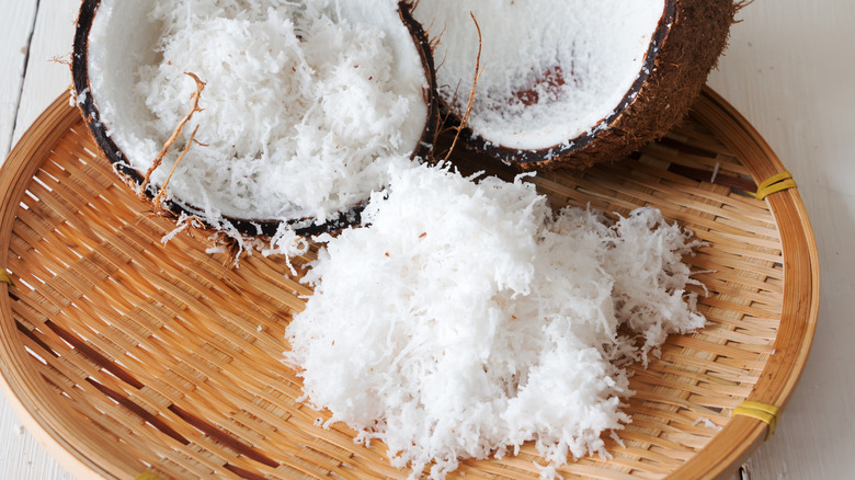 Coconut halves with shredded coconut on woven platter