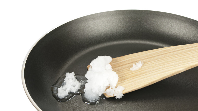 Coconut oil on spatula in pan