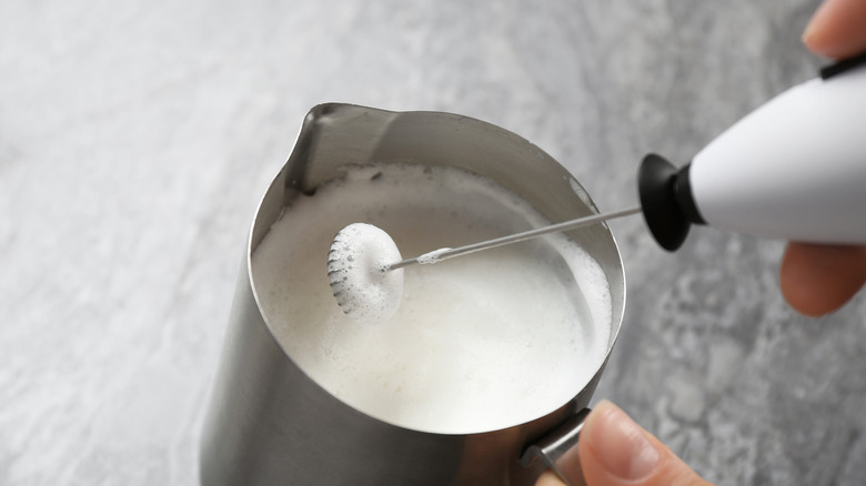 Person using milk frother