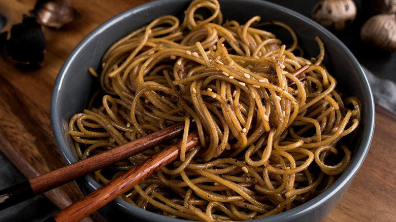 Sesame noodles in a bowl with chopsticks