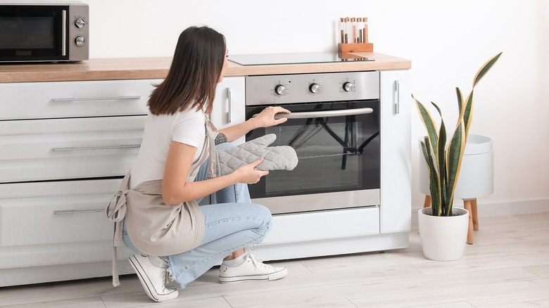 Woman checking oven