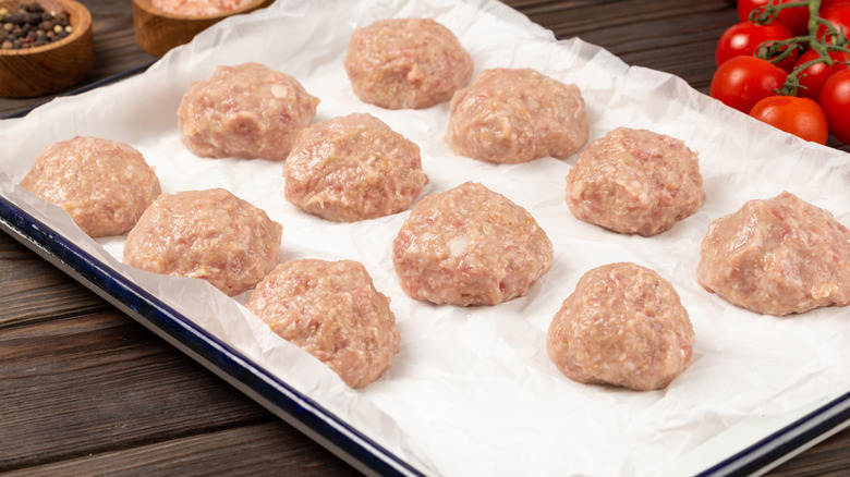 Raw meatballs on baking sheet