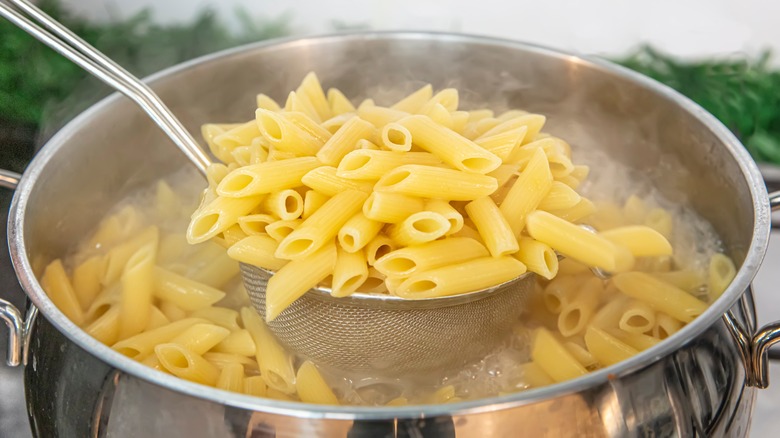 Draining cooked penne pasta