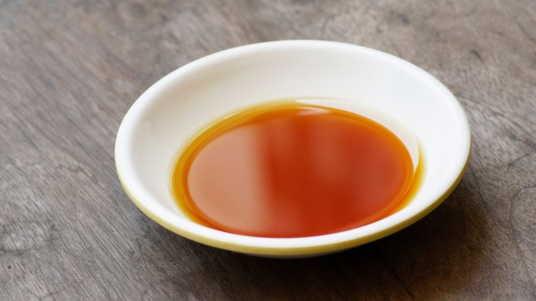 A small, white dish with fish sauce