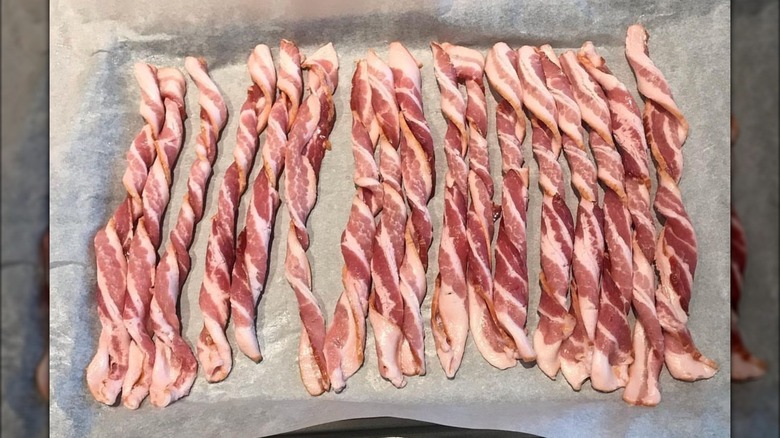 Tray full of twisted bacon strips.