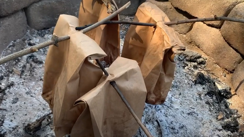 Cooking bacon and eggs in a paperbag over the campfire