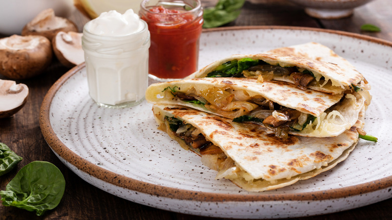 Steak quesadilla on plate with sauces